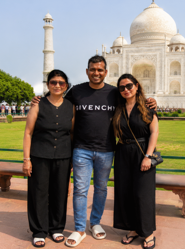 Family standing together for a photo in front of the Taj Mahal during a sunrise Taj Mahal tour