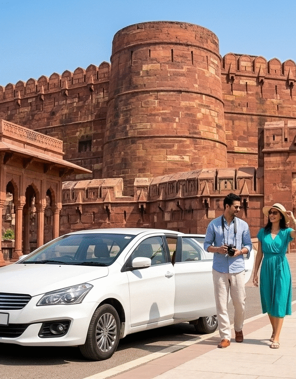 A white private tour car parked in front of the massive red sandstone walls and fortified entrance of Agra Fort. A couple is seen walking toward the monument, capturing the scale of this UNESCO World Heritage site.