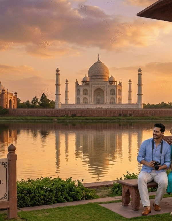 A couple sitting on a stone bench in the Mehtab Bagh gardens, enjoying the view of the Taj Mahal across the river during the "golden hour." A white private car is parked nearby under a stone pavilion, emphasizing comfort and convenience.
