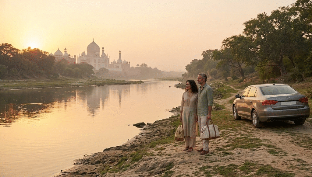 A man and woman standing on the sandy banks of the Yamuna River, peacefully viewing the Taj Mahal in the distance during a hazy sunrise. A silver car is parked on a nearby dirt path, emphasizing a private, off-the-beaten-path moment.