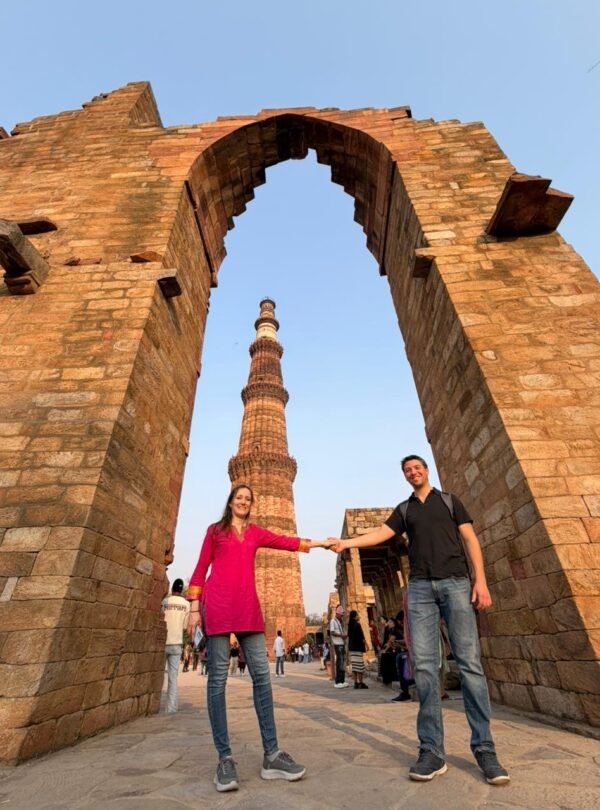 Tourists posing near historical ruins at Qutub Minar during an Old and New Delhi Tour