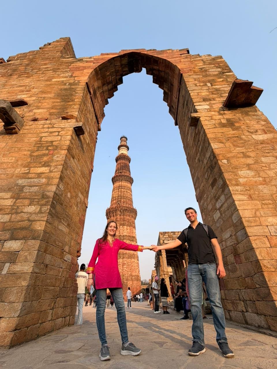 Tourists posing near historical ruins at Qutub Minar during an Old and New Delhi Tour