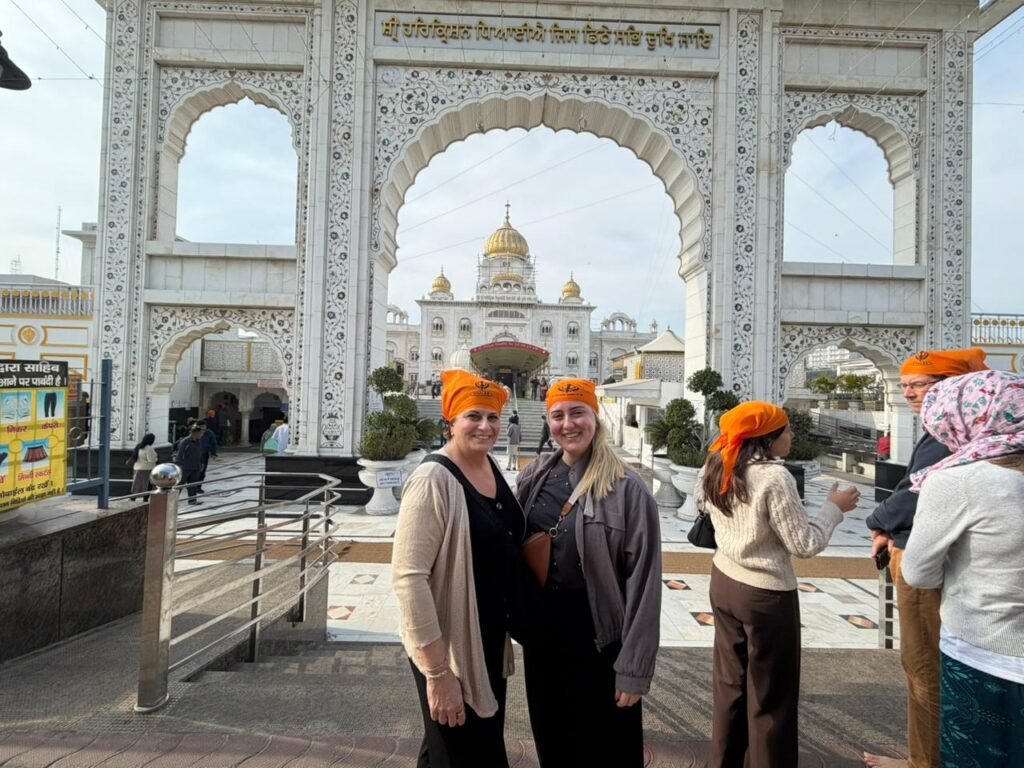 Delhi Temples and Spiritual Sites Tour visitors posing at Gurudwara Bangla Sahib during a spiritual sightseeing experience in Delhi