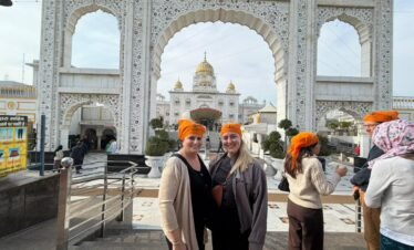 Delhi Temples and Spiritual Sites Tour visitors posing at Gurudwara Bangla Sahib during a spiritual sightseeing experience in Delhi
