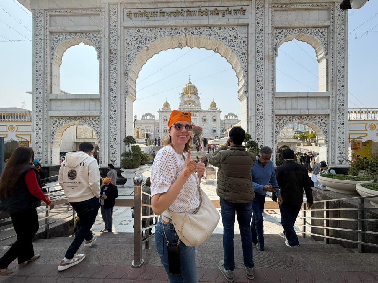 Tourists posing under a grand historical stone archway during a Same Day Delhi Tour By Car