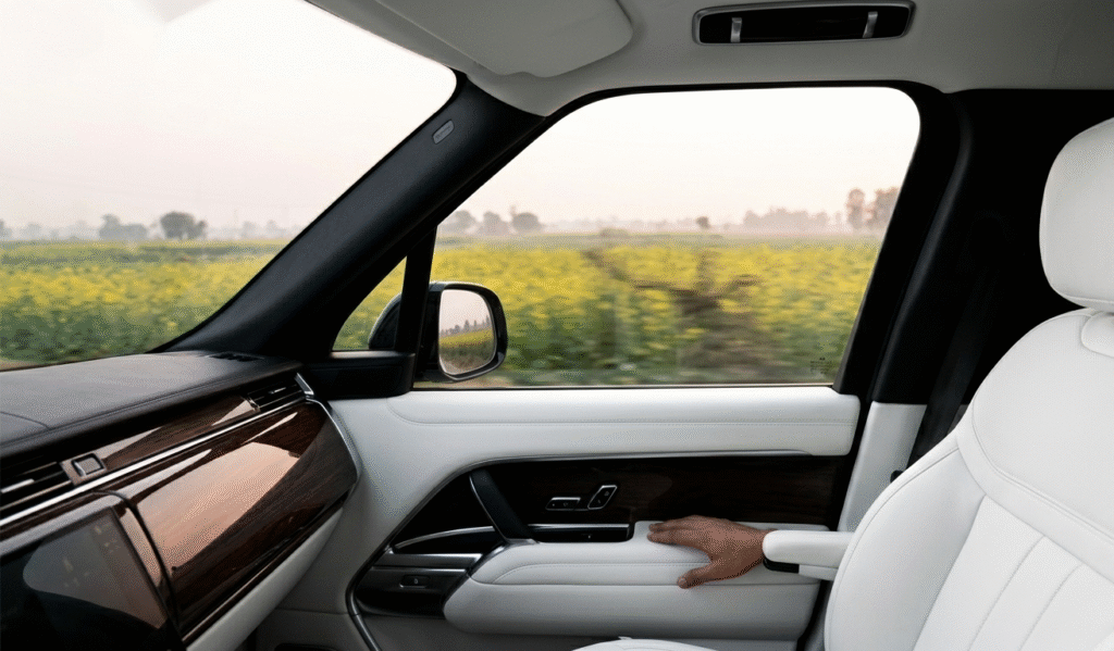 Luxury Golden Triangle tour India interior of private air-conditioned vehicle viewing rural landscape.