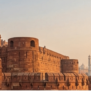 A premium Agra Fort tour showing the red sandstone architecture of the Lal Kila Agra during sunset.