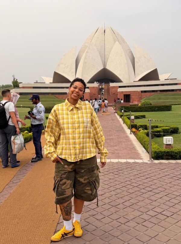 Tourist in a yellow shirt posing in front of the Lotus Temple during a Private Delhi Tour