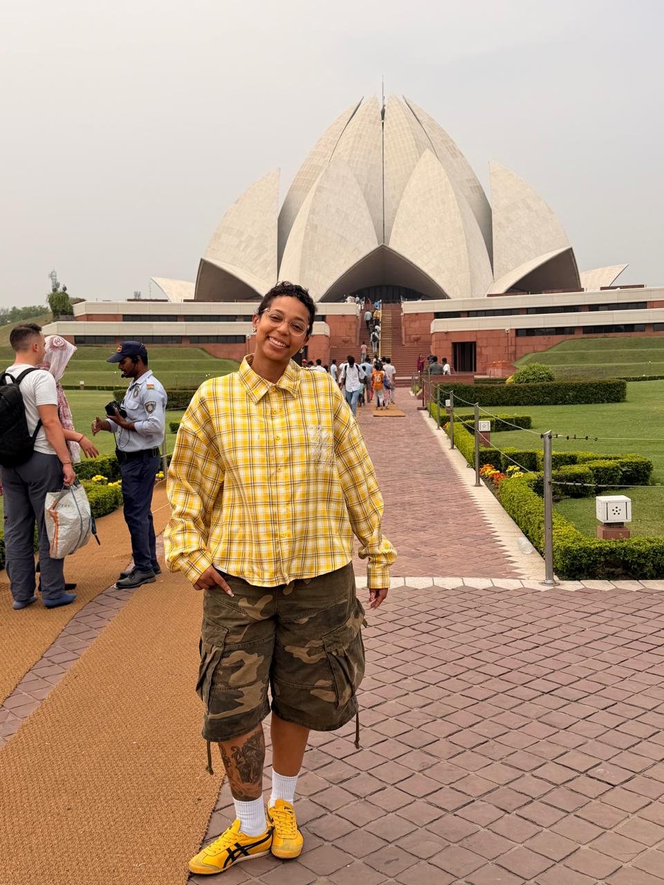 Tourist in a yellow shirt posing in front of the Lotus Temple during a Private Delhi Tour