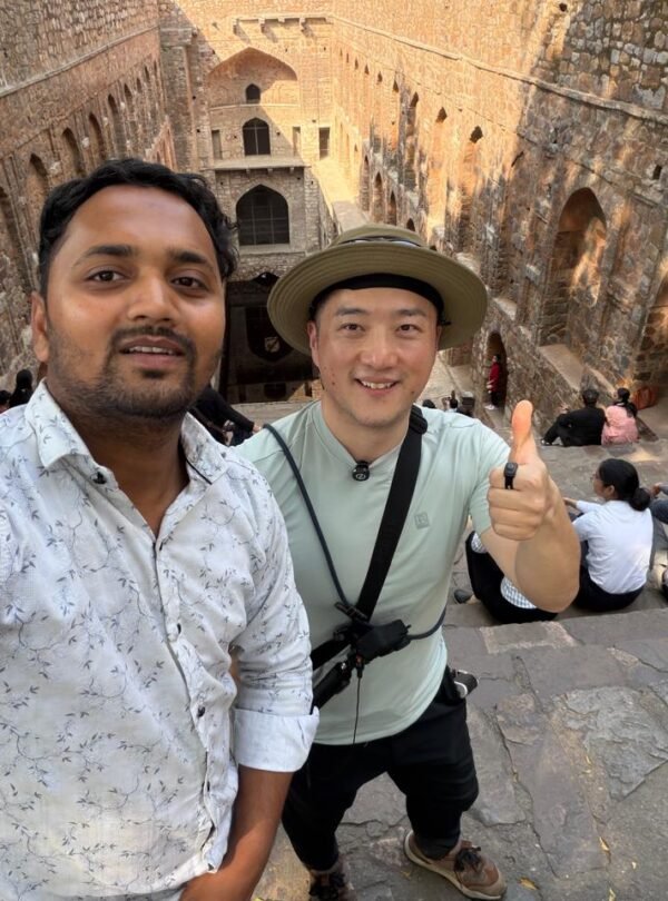 Tourists posing near heritage ruins during a private half day delhi tour