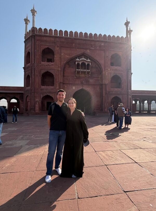 Travelers exploring a historic red sandstone monument during a Delhi Temples Tour