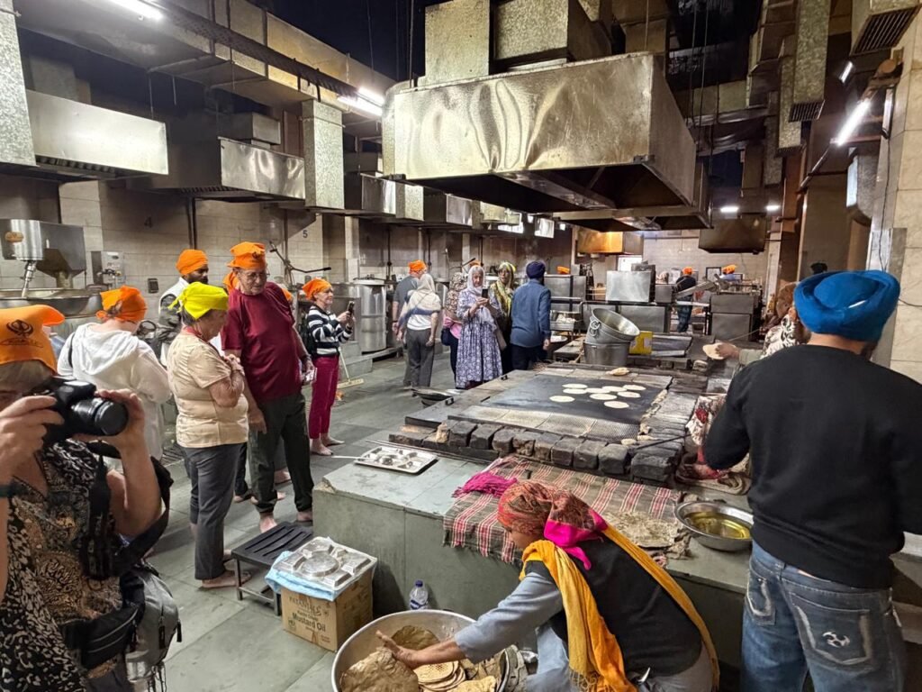 Delhi Temples and Spiritual Sites Tour visitors exploring the community kitchen (Langar Hall) at Gurudwara Bangla Sahib in Delhi