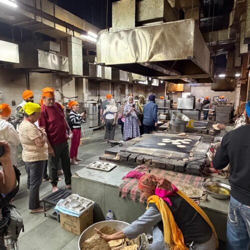 Delhi Temples and Spiritual Sites Tour visitors exploring the community kitchen (Langar Hall) at Gurudwara Bangla Sahib in Delhi