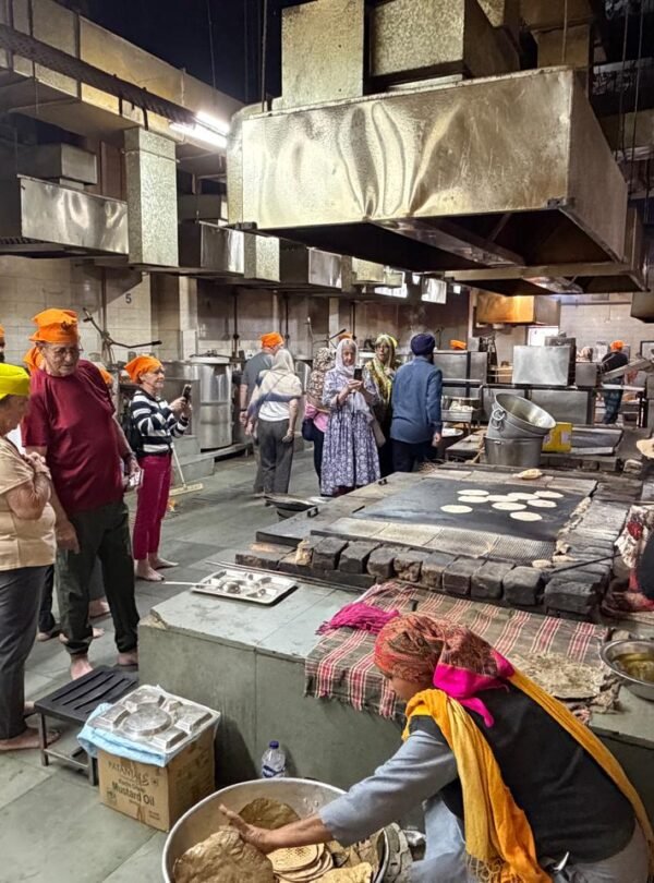 Delhi Temples and Spiritual Sites Tour visitors exploring the community kitchen (Langar Hall) at Gurudwara Bangla Sahib in Delhi