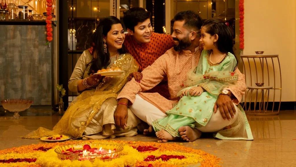 Indian family celebrating Diwali Festival of Lights at home with traditional attire, diyas, and festive decorations