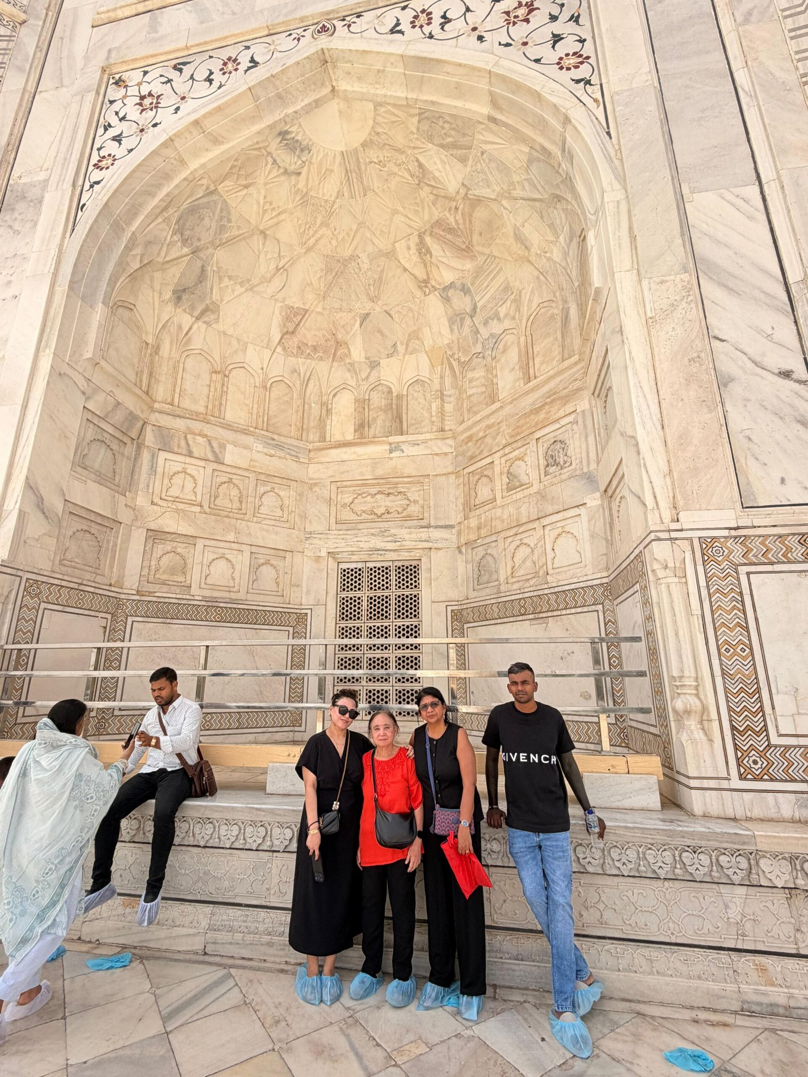 Travelers exploring the intricate marble interior of the Taj Mahal during a Golden Triangle Tour with Varanasi