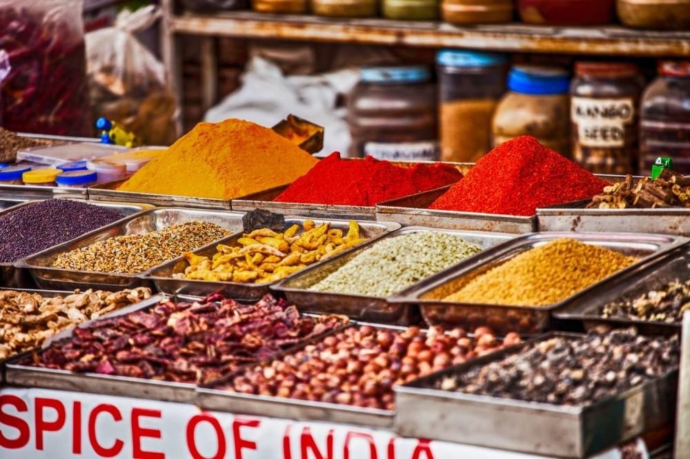 Authentic Indian spices including turmeric, red chilli, cardamom, and cumin displayed in a traditional spice market, one of the best gifts from India.